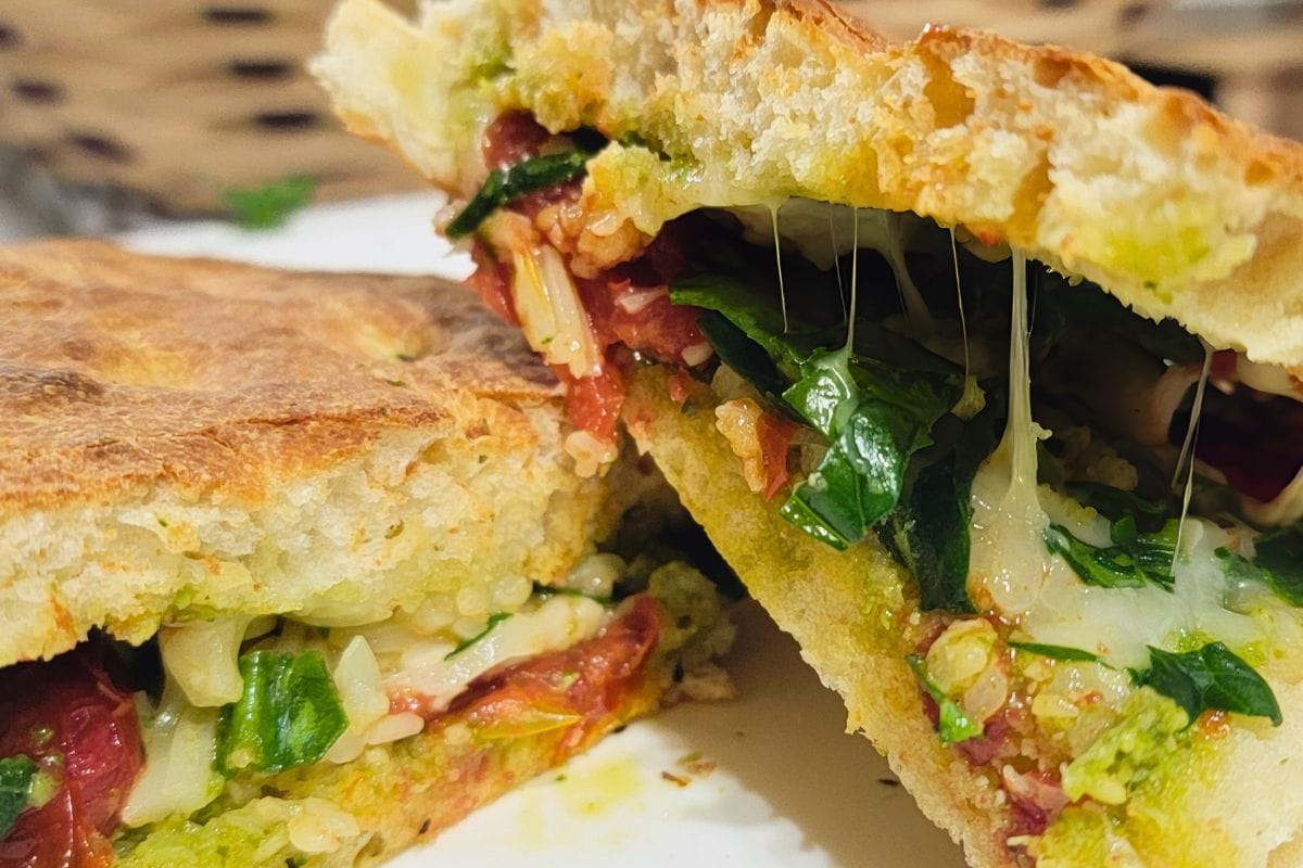 sheet pan focaccia bread stuffed with basil pesto, cheese, and roasted tomatoes